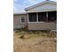 House exterior shows overgrown lawn, small porch, and beige painted siding at 1609 W Maki Rd, Plant City, FL 33566