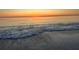 Calm beach scene at sunset with gentle waves washing onto the sandy shore at 101 95Th Ave, Treasure Island, FL 33706