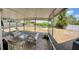 Covered back porch with cushioned furniture and a glass table, overlooking a large, fenced yard at 13122 Cumberland Dr, Largo, FL 33773