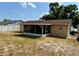Rear exterior view of the home with a screened lanai and spacious backyard at 13122 Cumberland Dr, Largo, FL 33773