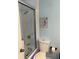 Cozy bathroom featuring a tiled shower with glass door and light blue walls with beach themed wall art at 13122 Cumberland Dr, Largo, FL 33773