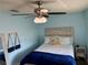 Cozy bedroom with blue walls, a ceiling fan, and a full-sized bed at 13122 Cumberland Dr, Largo, FL 33773