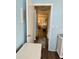 Hallway with wood floors and light blue walls leading to other rooms in the home at 13122 Cumberland Dr, Largo, FL 33773
