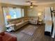 Comfortable living room with hardwood floors, a large sectional sofa, and natural light from the windows at 13122 Cumberland Dr, Largo, FL 33773