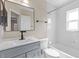 Bathroom with white vanity, gray cabinet, and tiled shower at 1904 Crown Park Dr, Valrico, FL 33594