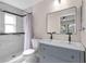Bathroom features a double sink, a gray cabinet, and a marbled tile shower and floor at 1904 Crown Park Dr, Valrico, FL 33594