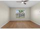 A comfortable bedroom with hardwood floors has a ceiling fan and a view of the neighborhood from the window at 1904 Crown Park Dr, Valrico, FL 33594