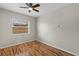 A bright bedroom showcases wood floors, a ceiling fan, and a window with a view of the neighborhood at 1904 Crown Park Dr, Valrico, FL 33594