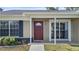 Inviting front porch with a red front door, large window and meticulously maintained landscaping at 1904 Crown Park Dr, Valrico, FL 33594