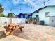 Charming backyard with brick-paved patio, wooden picnic table, and string lights, creating a cozy atmosphere at 2904 Sanchez St, Tampa, FL 33605