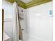Bathroom features white tiles, shower with curtain and shelving unit at 2904 Sanchez St, Tampa, FL 33605