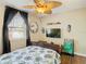 Bright bedroom with ceiling fan, mounted TV, and tropical-patterned bedding at 2904 Sanchez St, Tampa, FL 33605