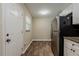 Compact kitchen with white cabinets, stainless appliances, and wood-look flooring, next to a door at 4812 N 37Th St, Tampa, FL 33610