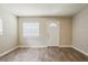 Bright living area featuring wood-look flooring, neutral paint, and a white front door at 4812 N 37Th St, Tampa, FL 33610
