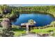 View of the lakeside pier with a gazebo surrounded by lush greenery in a serene setting at 8721 Crystal Creek Ct, Land O Lakes, FL 34638