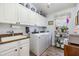 Functional laundry room with built-in cabinets, modern washer and dryer, and bright natural light at 8721 Crystal Creek Ct, Land O Lakes, FL 34638