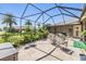 Spacious screened-in patio with comfortable seating and lush tropical plants at 8721 Crystal Creek Ct, Land O Lakes, FL 34638