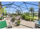 A screened-in patio featuring comfortable seating and lush tropical plants and a table at 8721 Crystal Creek Ct, Land O Lakes, FL 34638