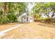Well-kept back yard with fencing, small trees, and a clear view of the back exterior of the home at 1424 14Th S St, St Petersburg, FL 33705