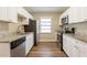 Well-lit kitchen featuring stainless steel appliances, granite countertops, and ample white cabinets at 1424 14Th S St, St Petersburg, FL 33705