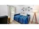 Cozy bedroom with a modern blue bed frame, stylish decor, and a bright window at 2356 Kingston S St, St Petersburg, FL 33711