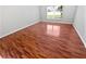 This bedroom features wood-look floors, a window, and neutral-painted walls at 2936 Banyan Hill Ln, Land O Lakes, FL 34639