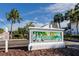 Palms of Tarpon Springs community sign against a sunny sky, with palm trees and lush landscaping at 738 Haven Pl, Tarpon Springs, FL 34689