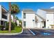 Exterior shot of condo with tropical landscaping, blue sky, and handicapped parking spot at 738 Haven Pl, Tarpon Springs, FL 34689