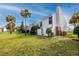 Townhouse with a well-maintained lawn, palm trees and updated exterior at 738 Haven Pl, Tarpon Springs, FL 34689
