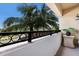 Balcony with black metal railings offers a peaceful outdoor retreat, with lush palm trees and a view of the surrounding area at 1064 N Tamiami Trl # 1219, Sarasota, FL 34236