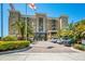 Well-maintained building exterior with neatly manicured landscaping, palm trees, and brick paver parking area at 1064 N Tamiami Trl # 1219, Sarasota, FL 34236