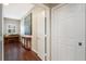 Hallway with hardwood floors, decorative painting, piano, and wainscoting at 1064 N Tamiami Trl # 1219, Sarasota, FL 34236