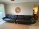 Living room featuring a modern black futon, a wicker mirror, and light-colored walls at 1064 N Tamiami Trl # 1219, Sarasota, FL 34236