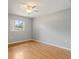 Neutral-painted bedroom featuring hardwood floors and a window with view of trees at 408 Eunice Dr, Plant City, FL 33563