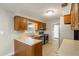 Galley kitchen with wood cabinets, stainless steel appliances, and tile flooring at 408 Eunice Dr, Plant City, FL 33563