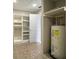Utility room featuring open shelving and water heater at 408 Eunice Dr, Plant City, FL 33563