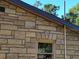 Exterior wall of home showing tan and brown bricks and a window with a tan frame at 820 Bayou Ave, Tarpon Springs, FL 34689