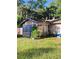 Cozy home with stone siding and a charming sunroom, surrounded by lush greenery at 820 Bayou Ave, Tarpon Springs, FL 34689