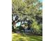 Yard with mature trees and shrubs leading to a one-story house at 820 Bayou Ave, Tarpon Springs, FL 34689