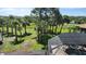 Expansive backyard featuring mature palm trees, lush greenery, and a screened-in pool at 2668 Jablo Cir, North Port, FL 34288