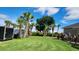 Large backyard featuring mature palm trees, manicured lawns, and lots of privacy at 2668 Jablo Cir, North Port, FL 34288