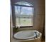 Relaxing bathroom featuring a soaking tub under a window, offering natural light and scenic views at 2668 Jablo Cir, North Port, FL 34288