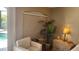 Bright bedroom featuring a large window, comfortable armchair, and elegant bedside table with lamp at 2668 Jablo Cir, North Port, FL 34288