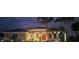 Charming single-story home featuring stucco exterior, a red front door, palm trees and manicured landscaping at 2668 Jablo Cir, North Port, FL 34288