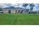 Well-maintained single-story home featuring arched windows, palm trees and a lush green lawn at 2668 Jablo Cir, North Port, FL 34288