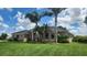 Well-maintained single-story home featuring arched windows, palm trees and a lush green lawn at 2668 Jablo Cir, North Port, FL 34288