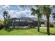 Screened patio with large seating area perfect for outdoor entertaining with lush backyard landscaping at 2668 Jablo Cir, North Port, FL 34288
