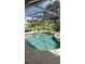 Backyard pool area surrounded by lush landscaping and an umbrella-covered dining set at 2668 Jablo Cir, North Port, FL 34288