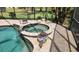Relaxing screened-in pool and jacuzzi area with colorful potted plants and lighting at 2668 Jablo Cir, North Port, FL 34288