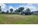 Expansive lot with green grass, some trees, and two trailer structures at 2668 Jablo Cir, North Port, FL 34288